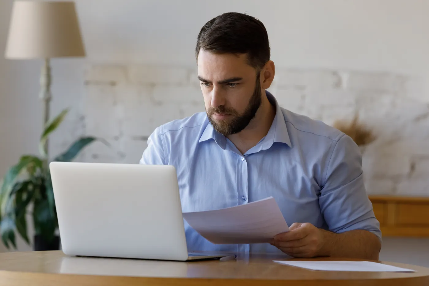 A Florida property owner reads a mailed notice at his desk beside a laptop